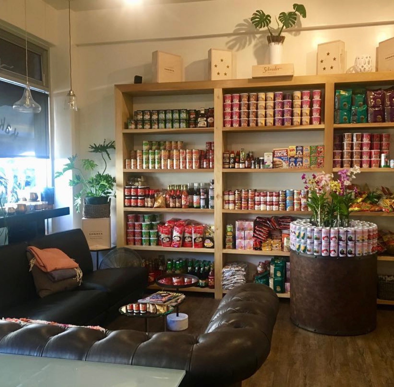 Inside Kaka'ako Market — leather lounge seating beside fully stocked retail shelves