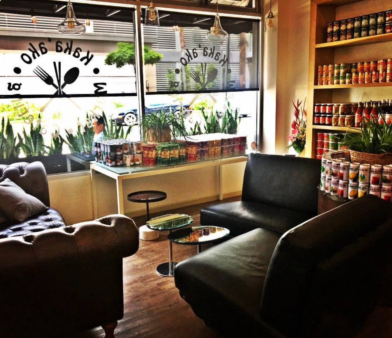 Storefront lounge seating by the front window with the Kaka'ako Market logo